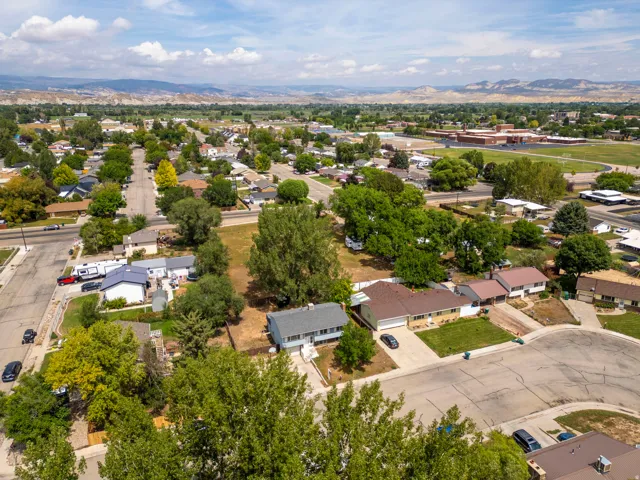 Aerial view showcasing this residential property situated on a tree-lined street within an established neighborhood