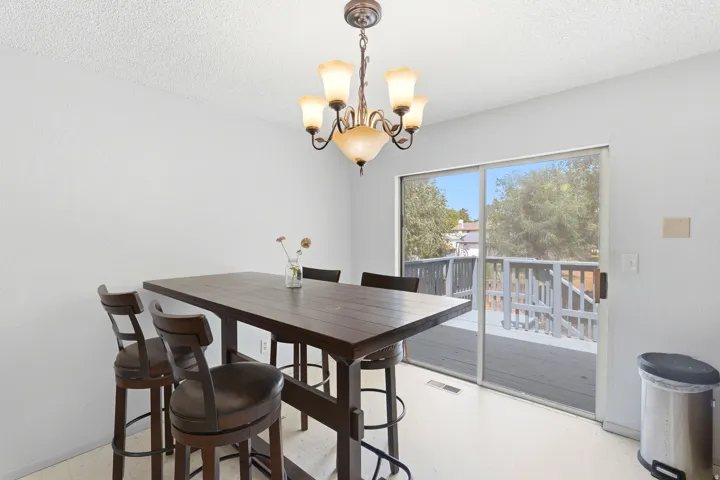 Modern dining area bathed in natural light from expansive sliding glass doors opening to a covered deck