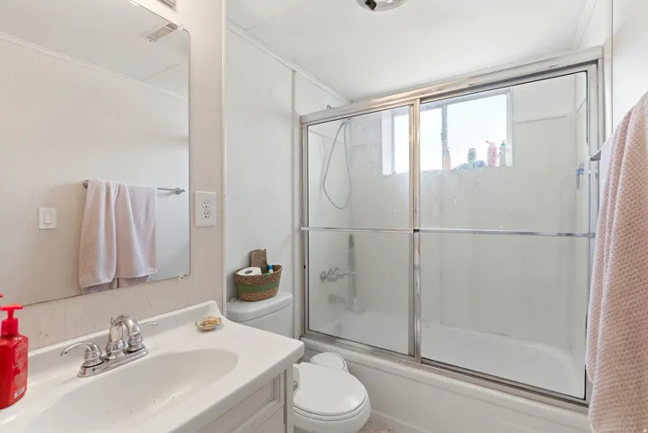 Contemporary bathroom featuring a frameless glass enclosed shower with chrome hardware, white subway tile surround, and polished chrome showerhead