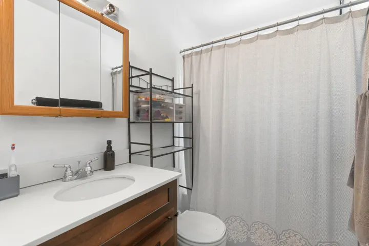 Wood-finish vanity with a white countertop and integrated sink