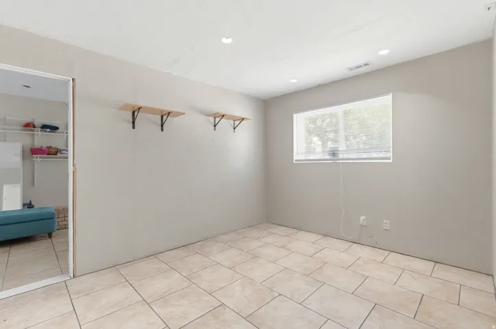 Tiled flooring, recessed lighting, and a window with blinds