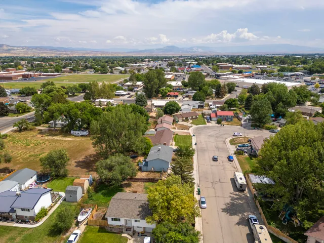 Aerial view showcasing this residential property situated on a tree-lined street within an established neighborhood