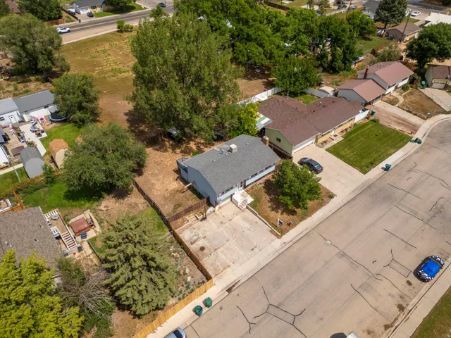 Single-story residence with a light gray roof, concrete driveway, and front lawn