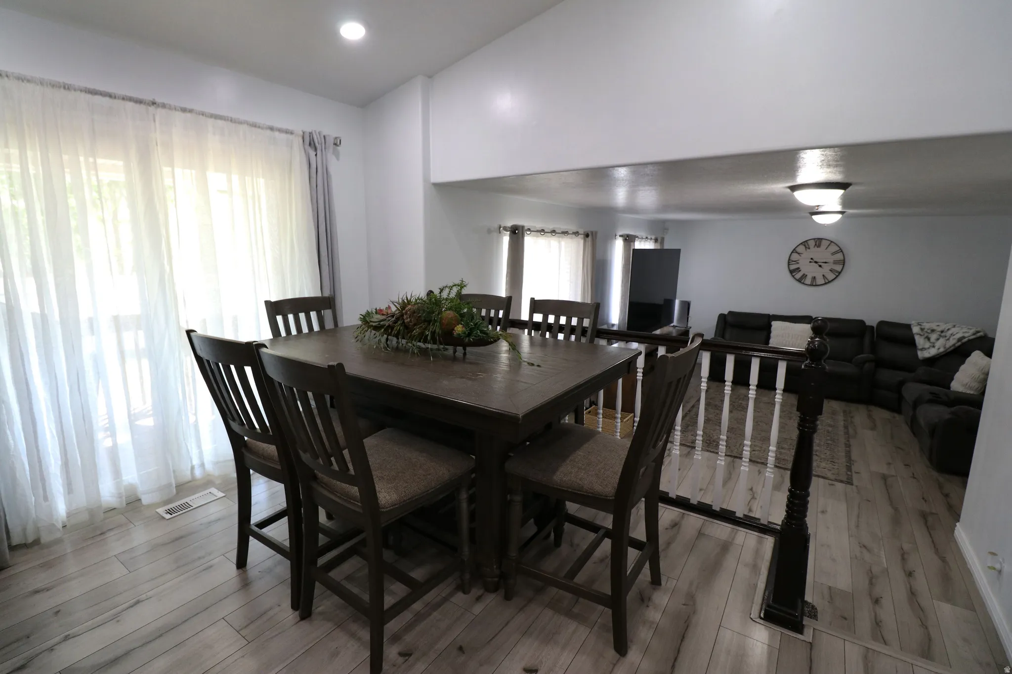 Open-concept dining area featuring wood-finish flooring, recessed lighting, and sliding glass doors