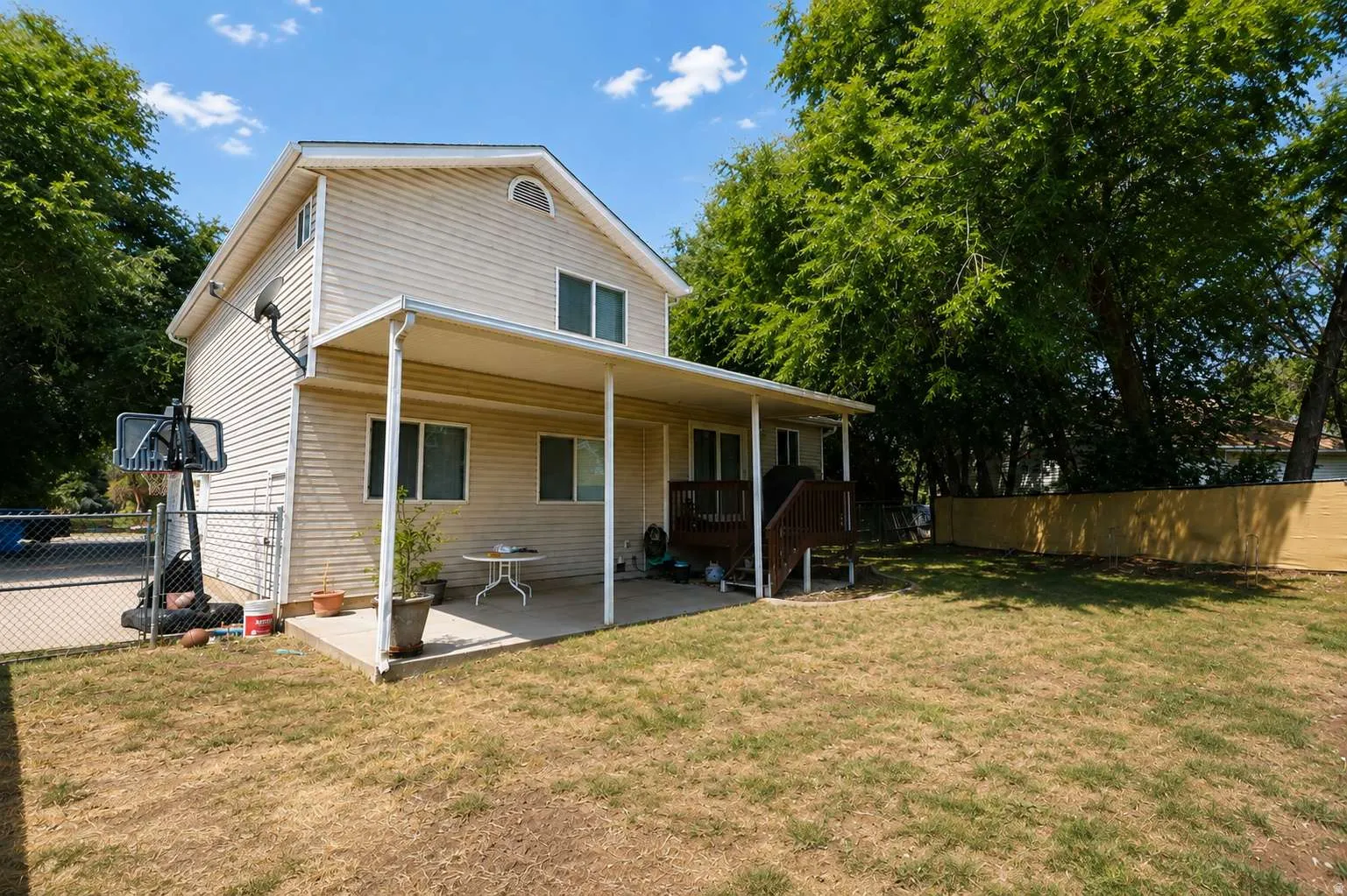 Charming cottage-style home featuring a covered front porch with beam supports, white vertical siding exterior, and multiple windows providing natural light