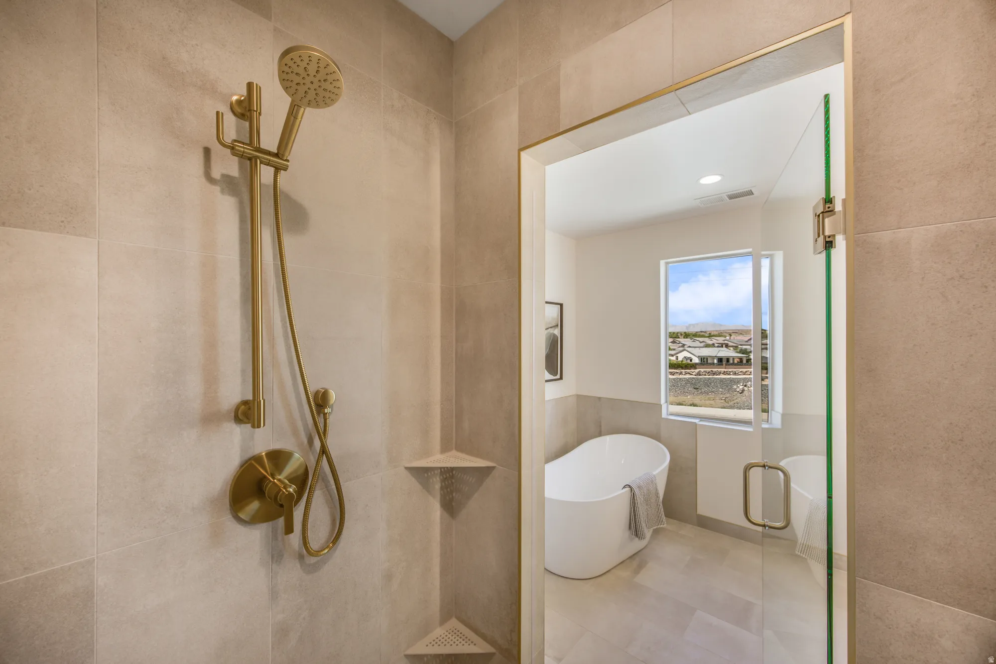 Walk-in shower with gold-finish fixtures and tiled walls