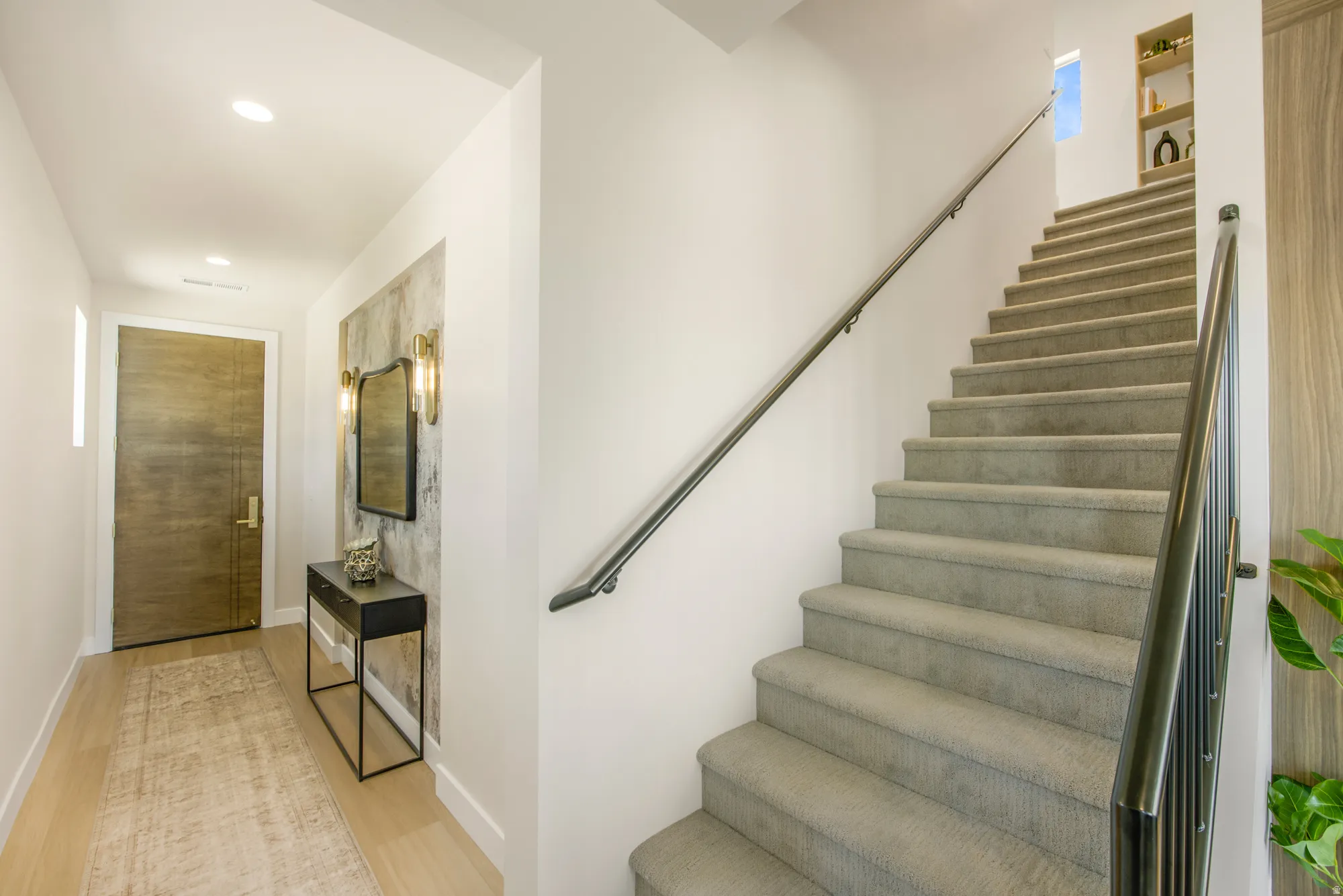 Light wood-finish flooring, recessed lighting, and a textured accent wall