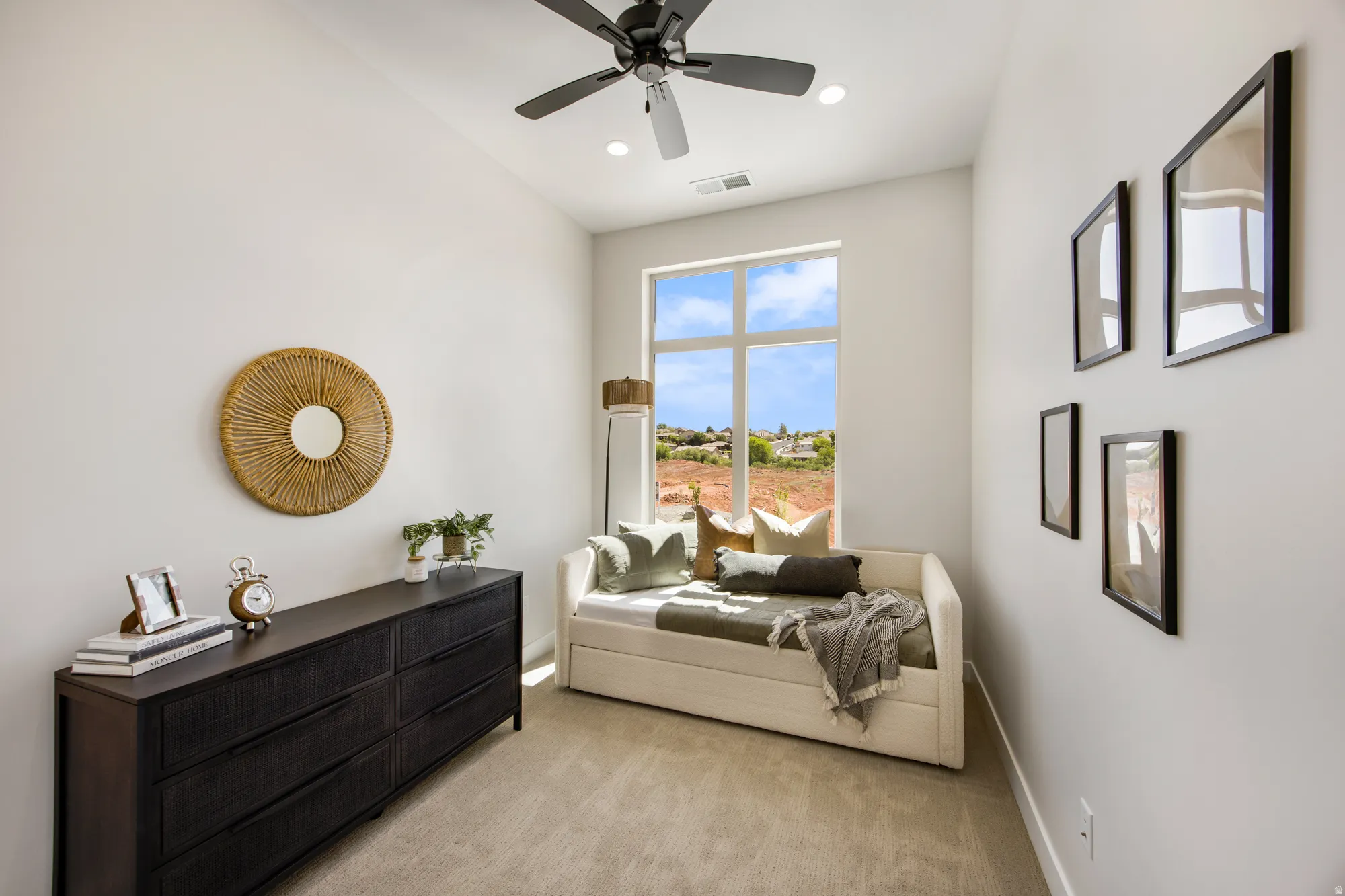 Vaulted ceiling with a ceiling fan and recessed lighting, large window with multi-pane design, neutral-toned carpet flooring, white walls, and built-in closet with dark wood-finish dresser