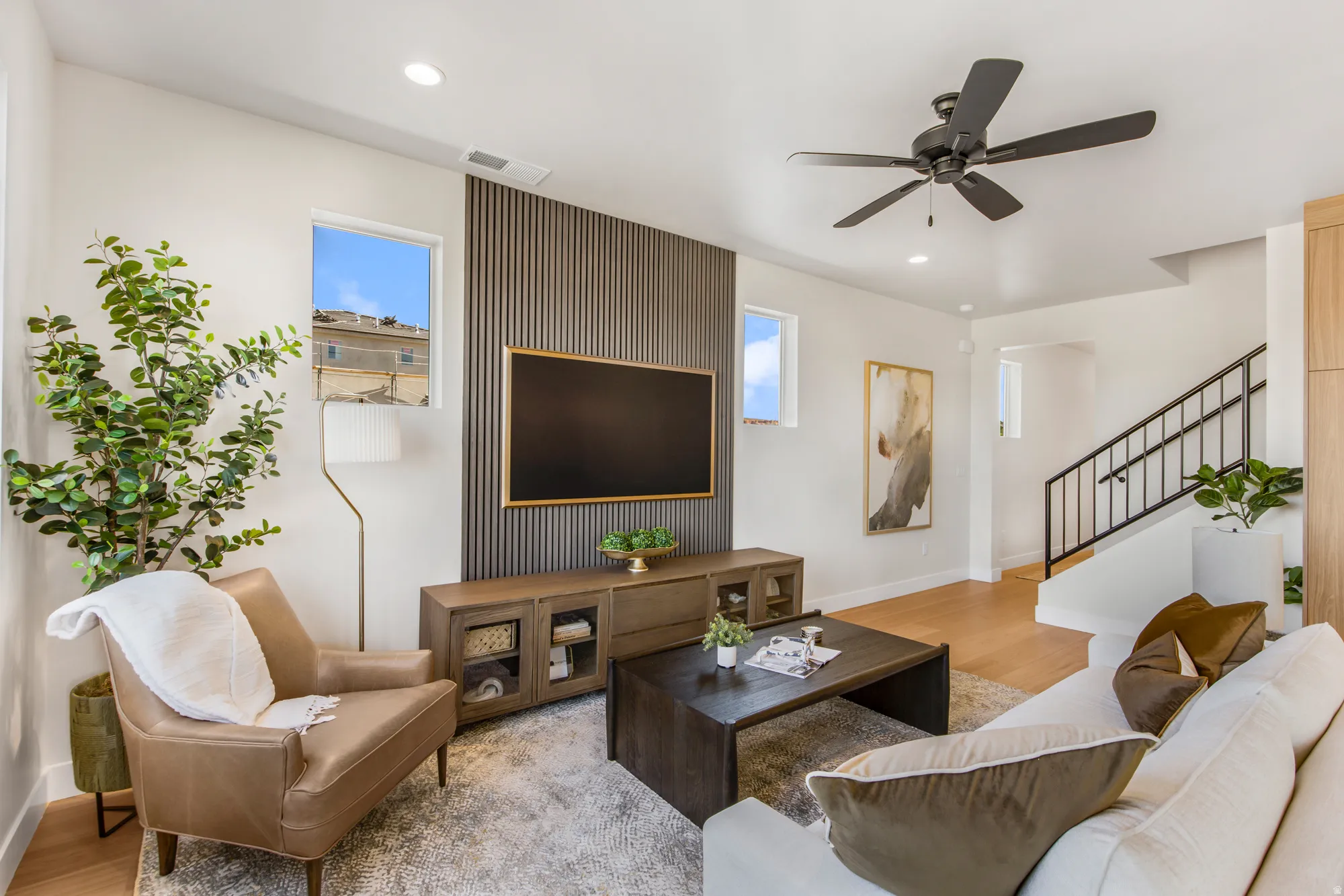 Open-concept living space with light wood-finish flooring, a contemporary ceiling fan, and recessed lighting