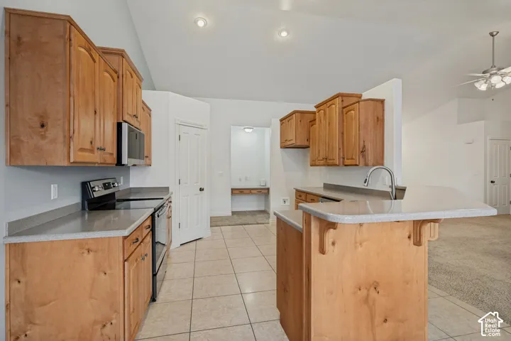Kitchen featuring wood cabinetry, light-toned countertops, and integrated appliances