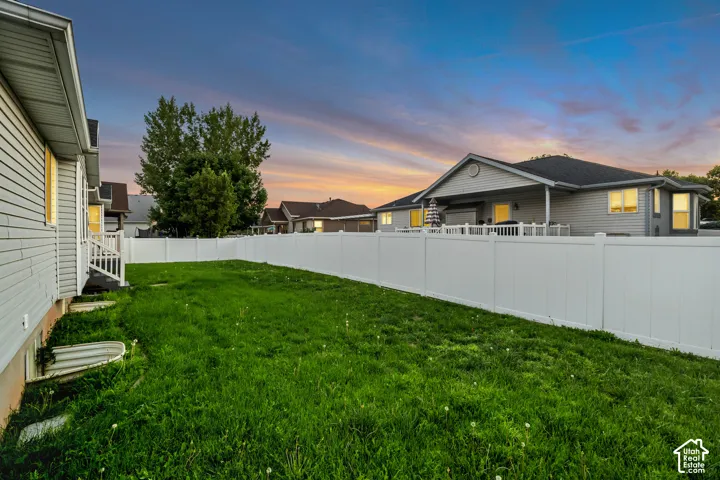 Expansive green space featuring a privacy fence and exterior siding