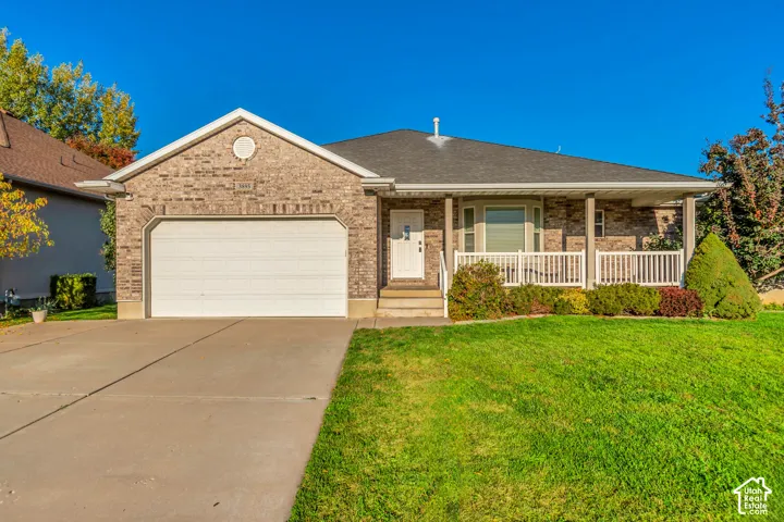 Brick-clad exterior with a covered front porch, white railing, bay window, and attached garage
