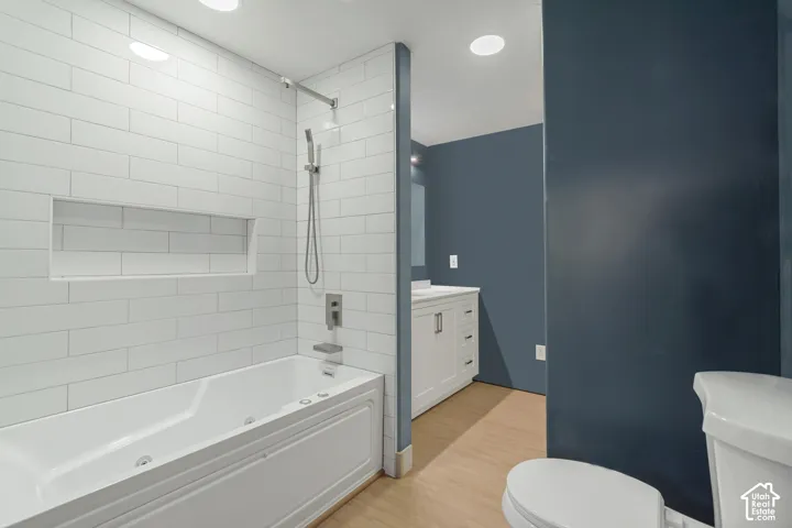 Soaking tub with integrated jets and white subway tile surround, featuring a recessed niche