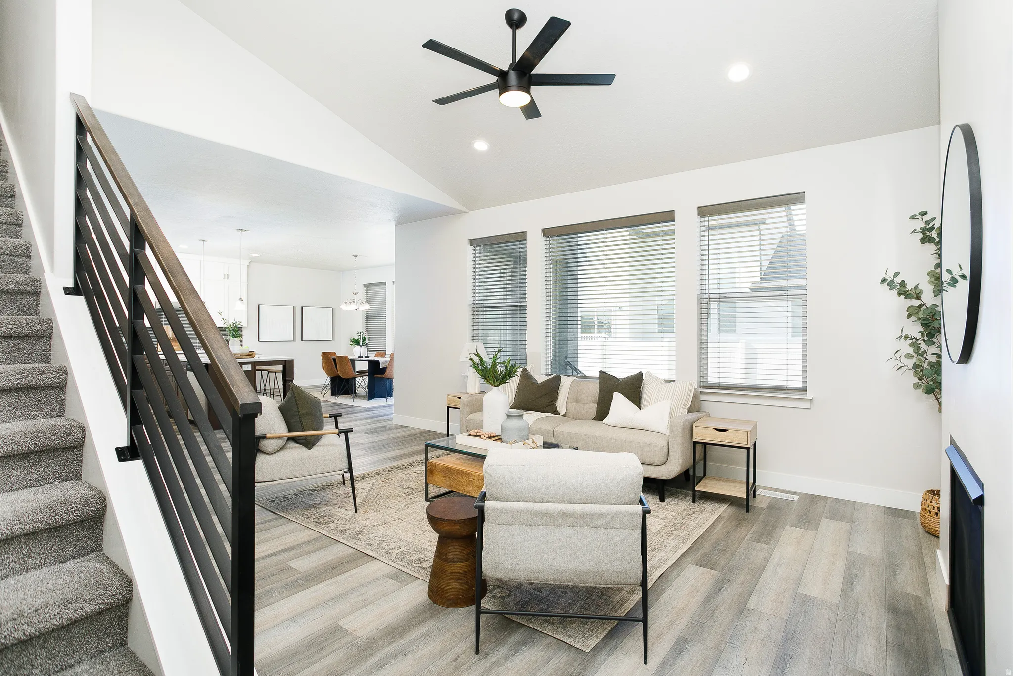 Living area featuring vaulted ceilings, wood-finish flooring, and a contemporary ceiling fan