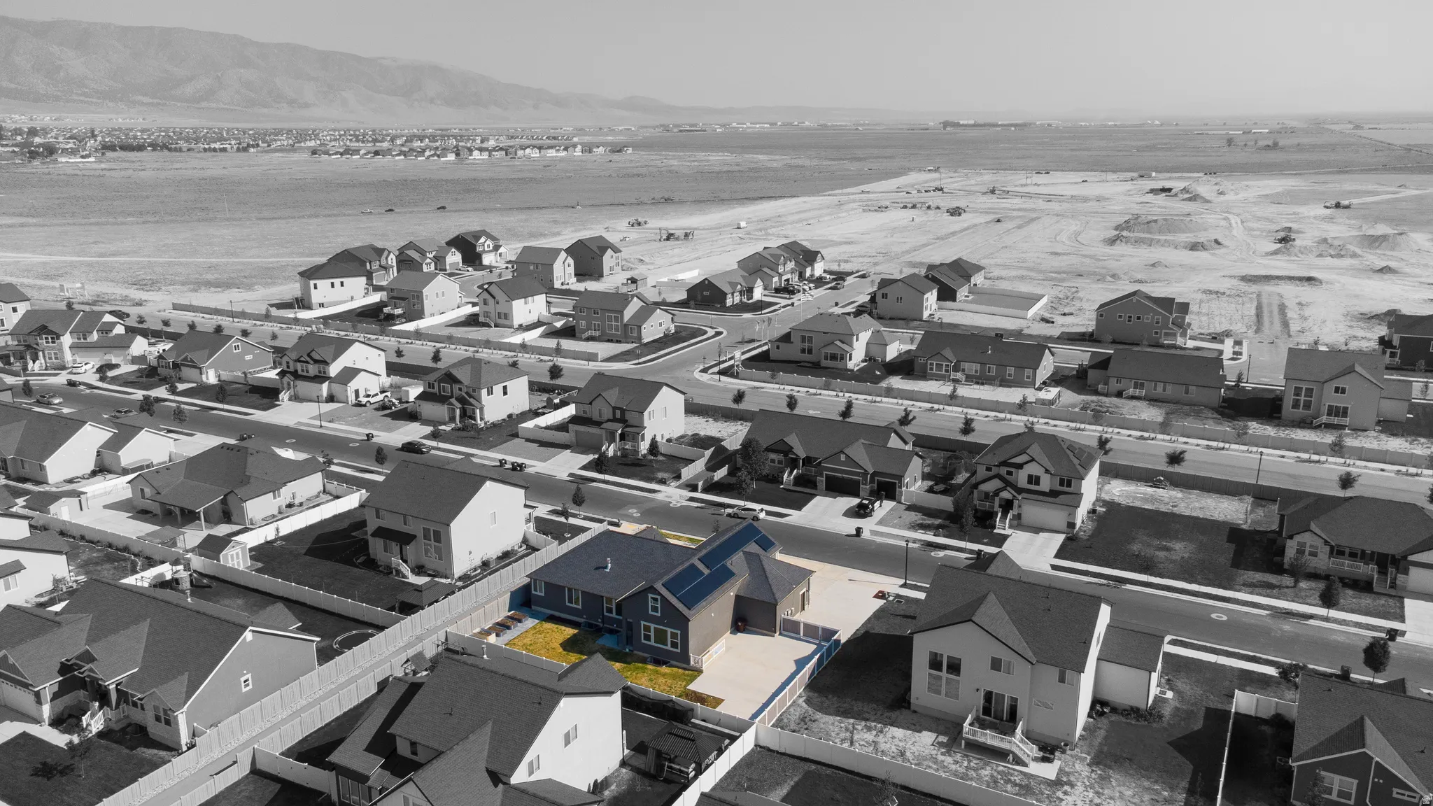Two-story residence with a gray exterior, attached garage, and solar panels