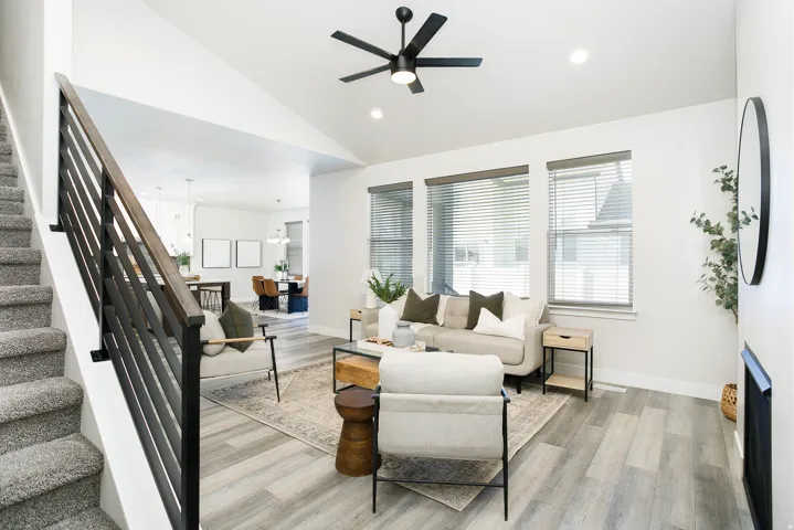 Living area featuring vaulted ceilings, wood-finish flooring, and a contemporary ceiling fan