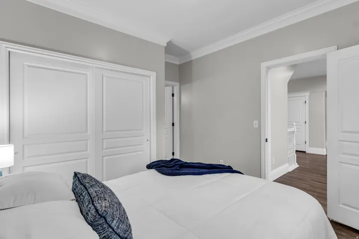 Main Level Bedroom featuring white panel  doors, neutral wall finishes, LVP flooring and an ensuite bathroom