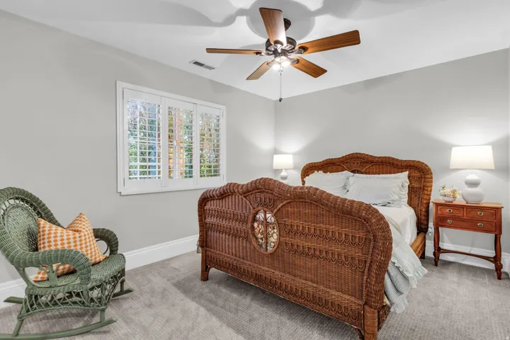 Upstairs bedroom - Window with plantation shutters, ceiling fan, and carpeted flooring