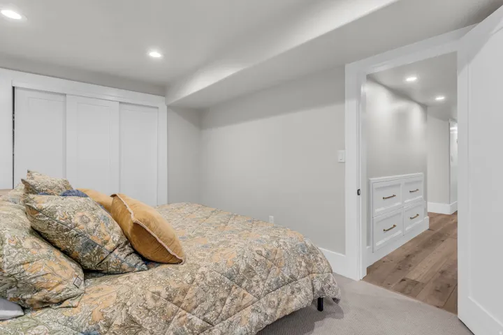 Basement Recessed lighting, wood-finish LVP flooring, built-in storage, and sliding closet doors