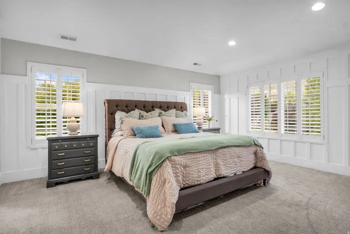 Master Bedroom (Upstairs)- Spacious primary bedroom with recessed ceiling lighting, and dual sets of plantation shutters flanking expansive windows