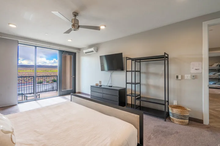 Sliding glass doors to a private balcony, recessed lighting, and a ceiling fan