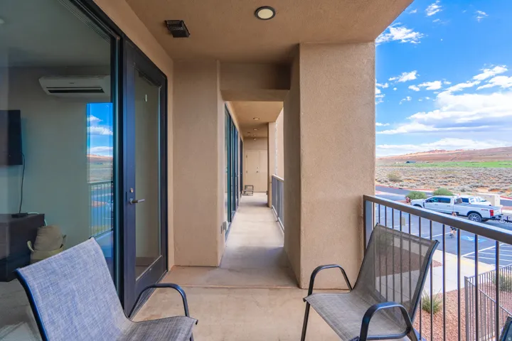 Expansive covered balcony with composite decking and metal railings, offering panoramic vistas of the surrounding landscape