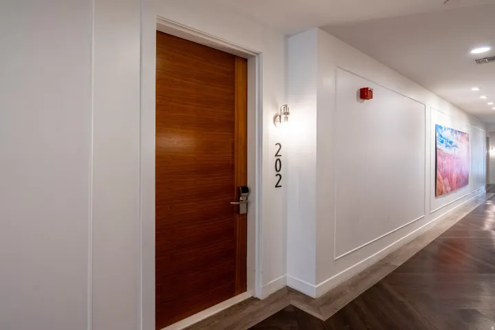 Wood-finish flooring in a herringbone pattern, wainscoting detailing, and recessed lighting