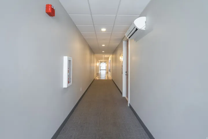 Long hallway featuring recessed lighting and wall-mounted sconces