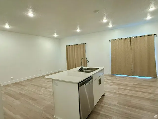 Kitchen island with an undermount double-basin sink, stainless steel faucet, and dishwasher