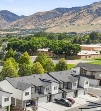 Townhome community with mountain scenery, mature trees, and individual garage access