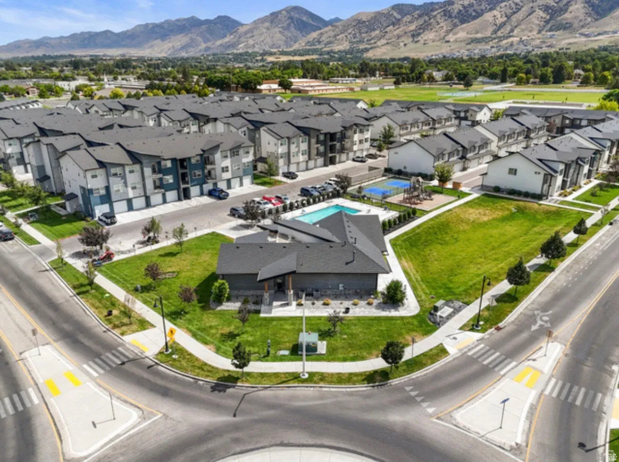 Community featuring a swimming pool, recreational court, playground, and multi-story residential buildings with attached garages