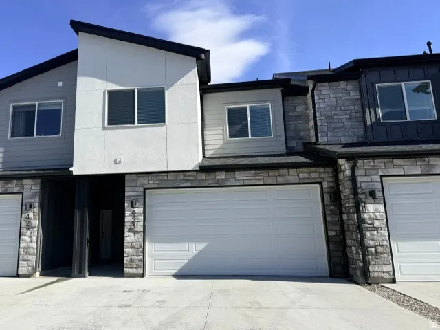 Contemporary exterior with a varied facade, featuring stone accents, stucco, and horizontal siding