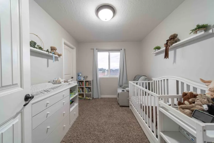Neutral wall paint, ceiling-mounted light fixture, and a window with natural light