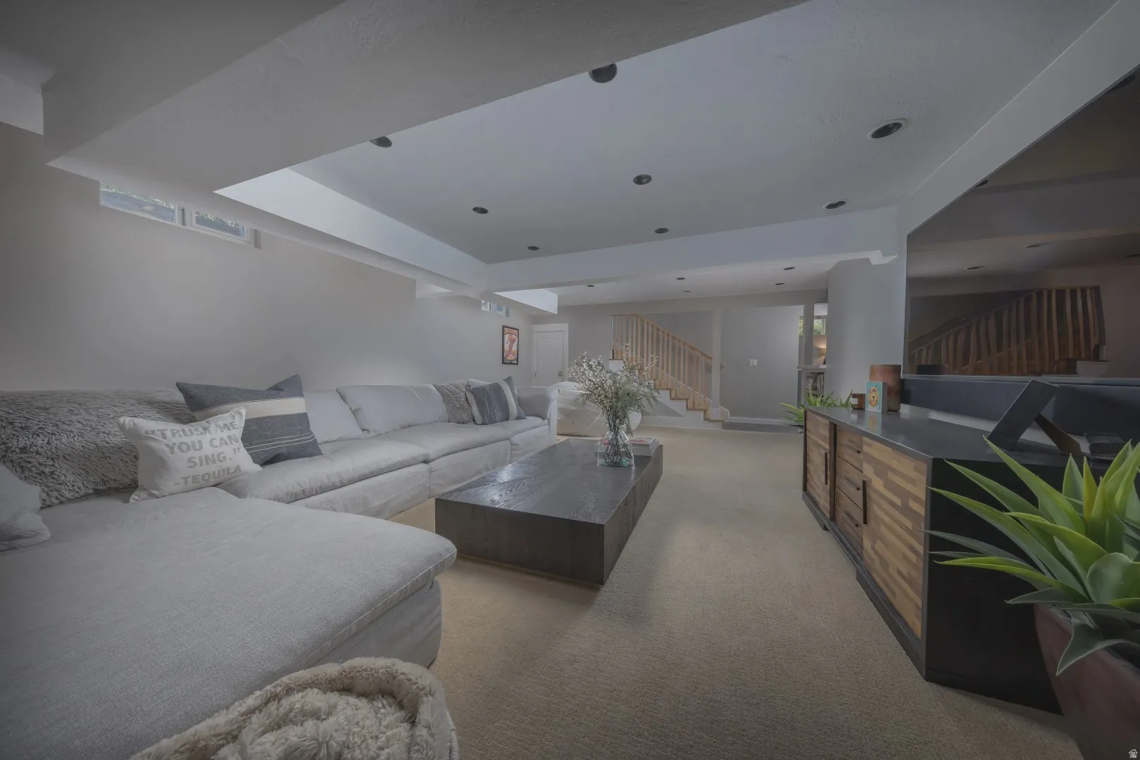 Recessed lighting, wood-finish console with storage, light gray walls, and carpet flooring