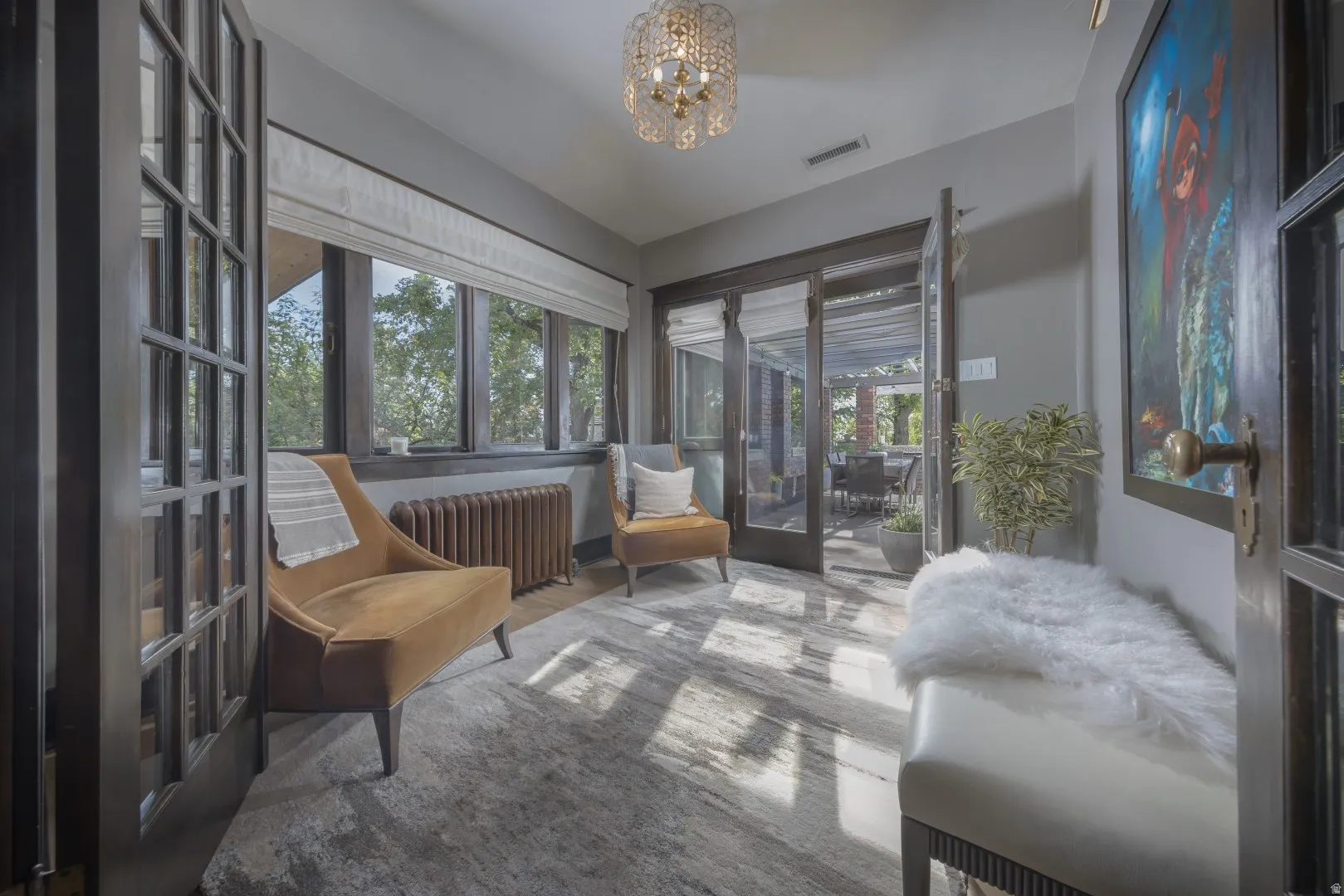 French doors with glass panels, wood-finish flooring, a crystal chandelier, and large windows with window treatments