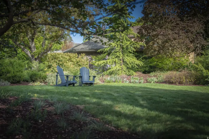 Expansive lawn with mature landscaping and established garden beds