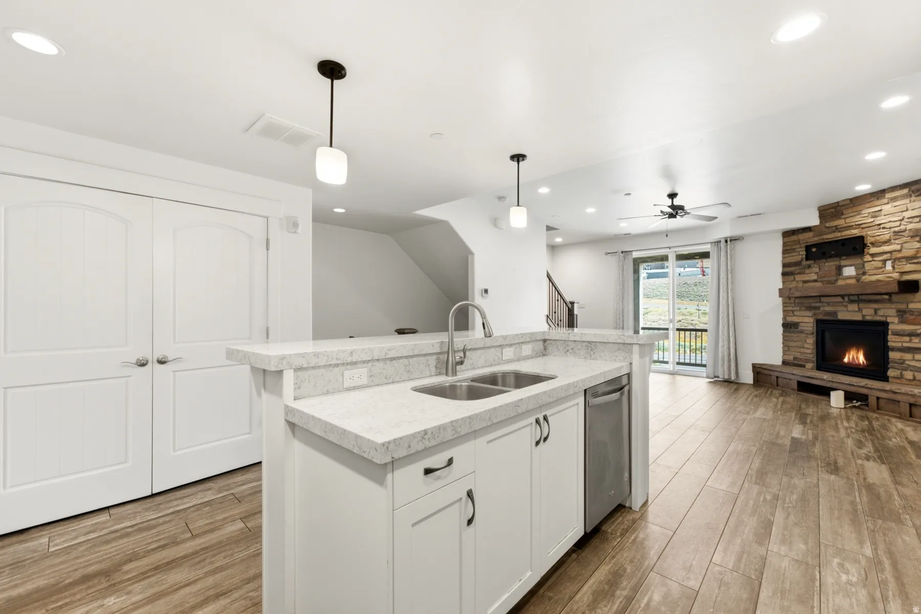 Chef's kitchen featuring a large center island with stainless steel appliances, white cabinetry, and quartz countertops
