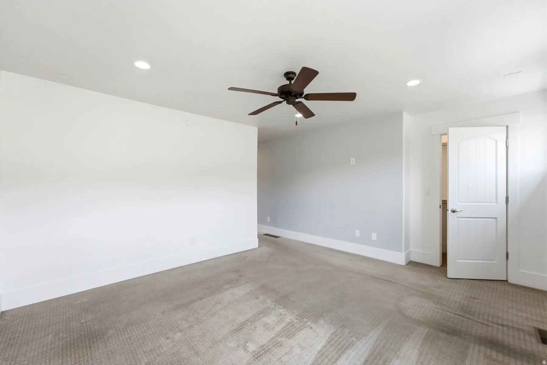 Recessed lighting, ceiling fan, white trim, paneled interior door, and carpet flooring