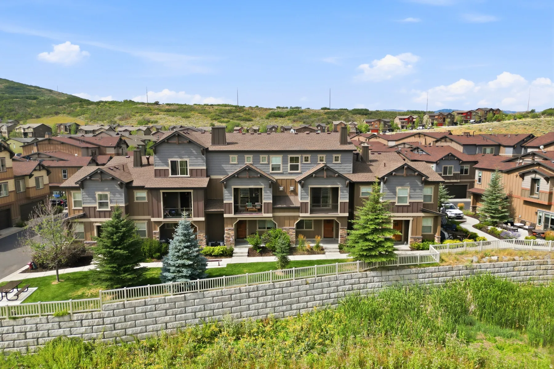 Modern townhome with multi-tone siding, stone accents, and private balconies