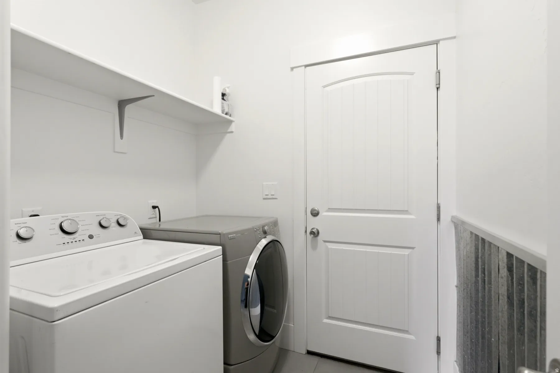 White storage shelving over laundry appliances