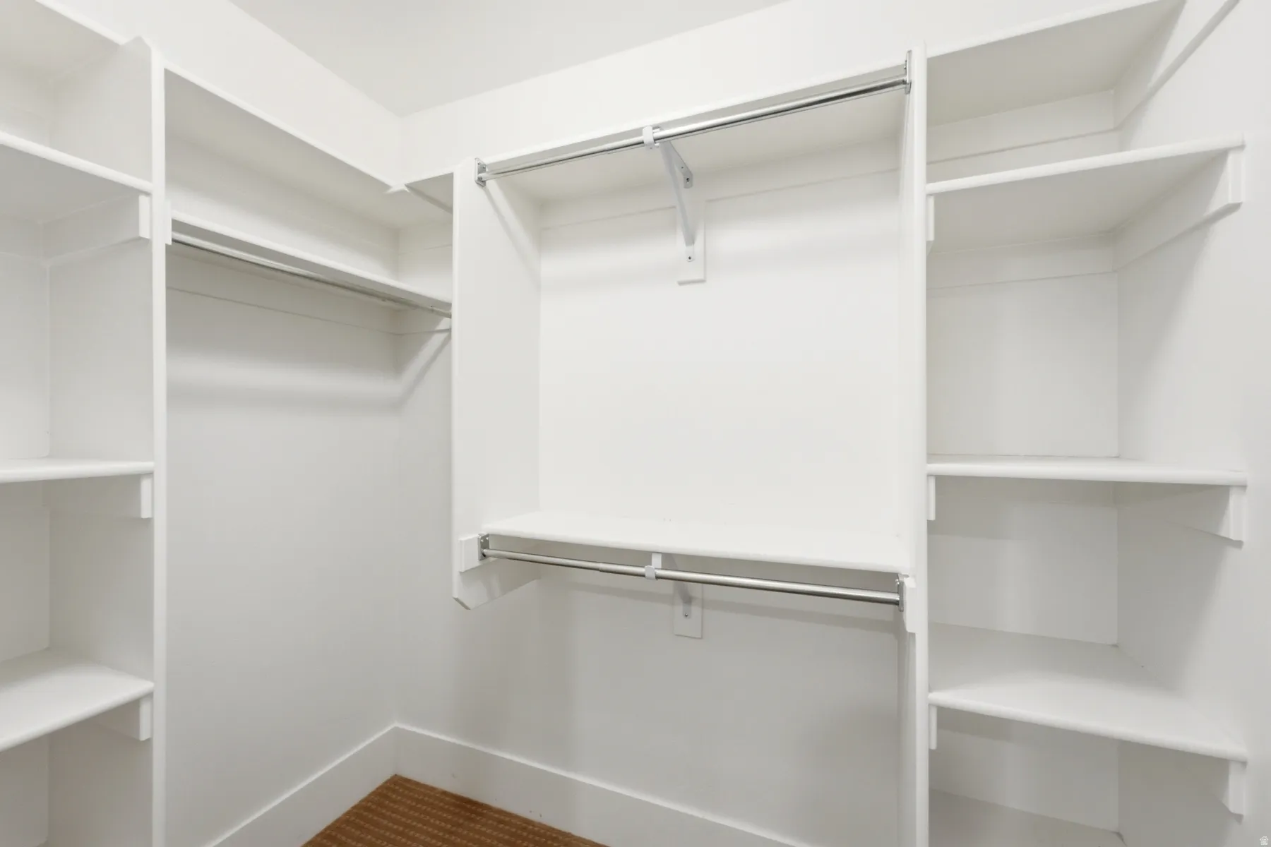 Built-in closet system featuring white shelving and chrome hanging rods