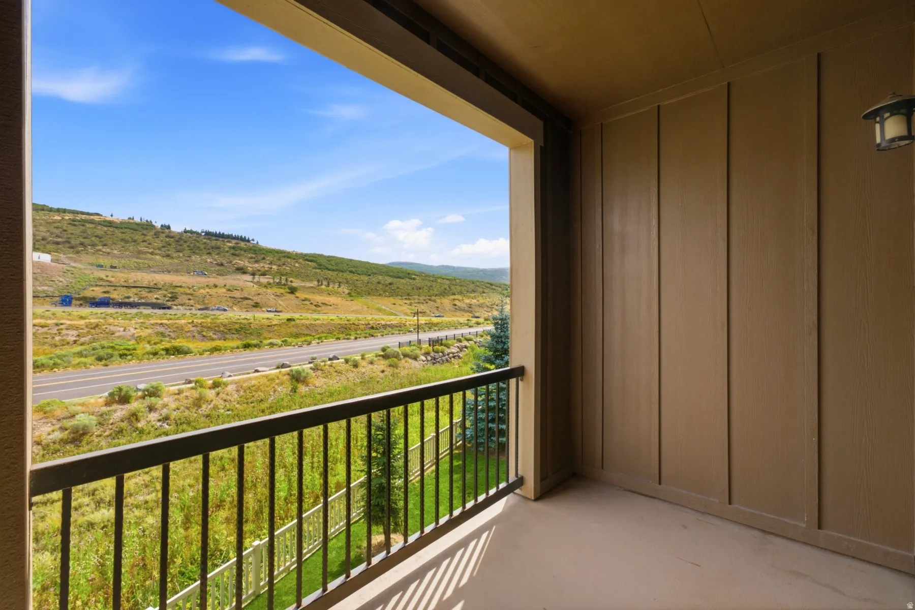Balcony featuring a metal railing, durable exterior siding, and an attached wall lantern