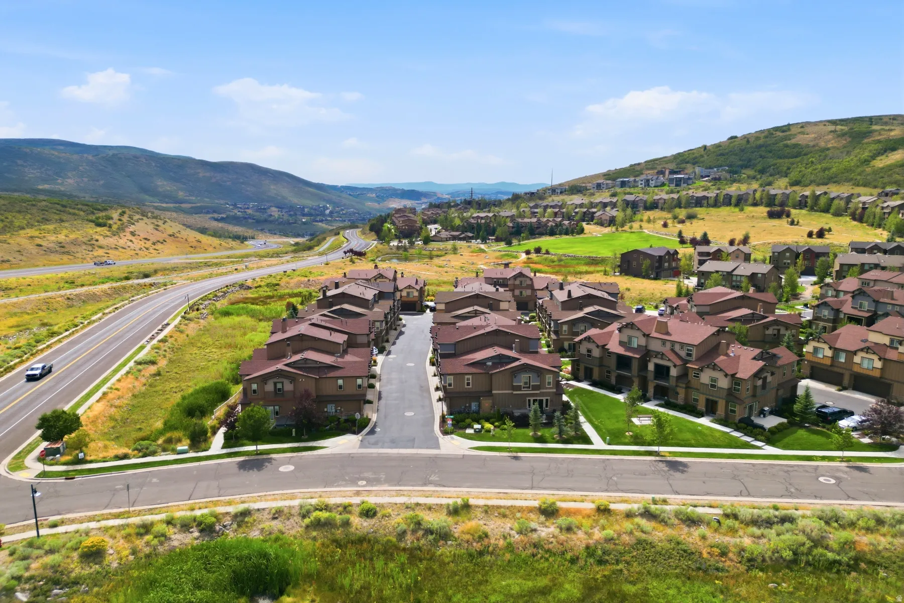 Residential community surrounded by natural landscapes and a paved road