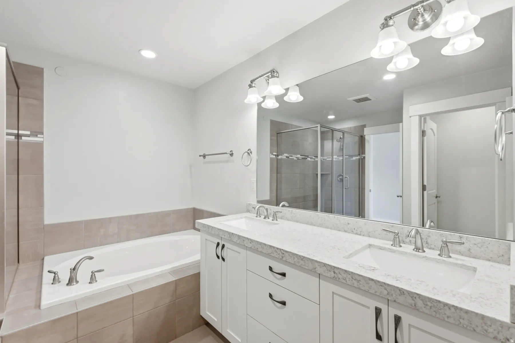 Dual vanity with undermount sinks, integrated countertop, and brushed nickel fixtures