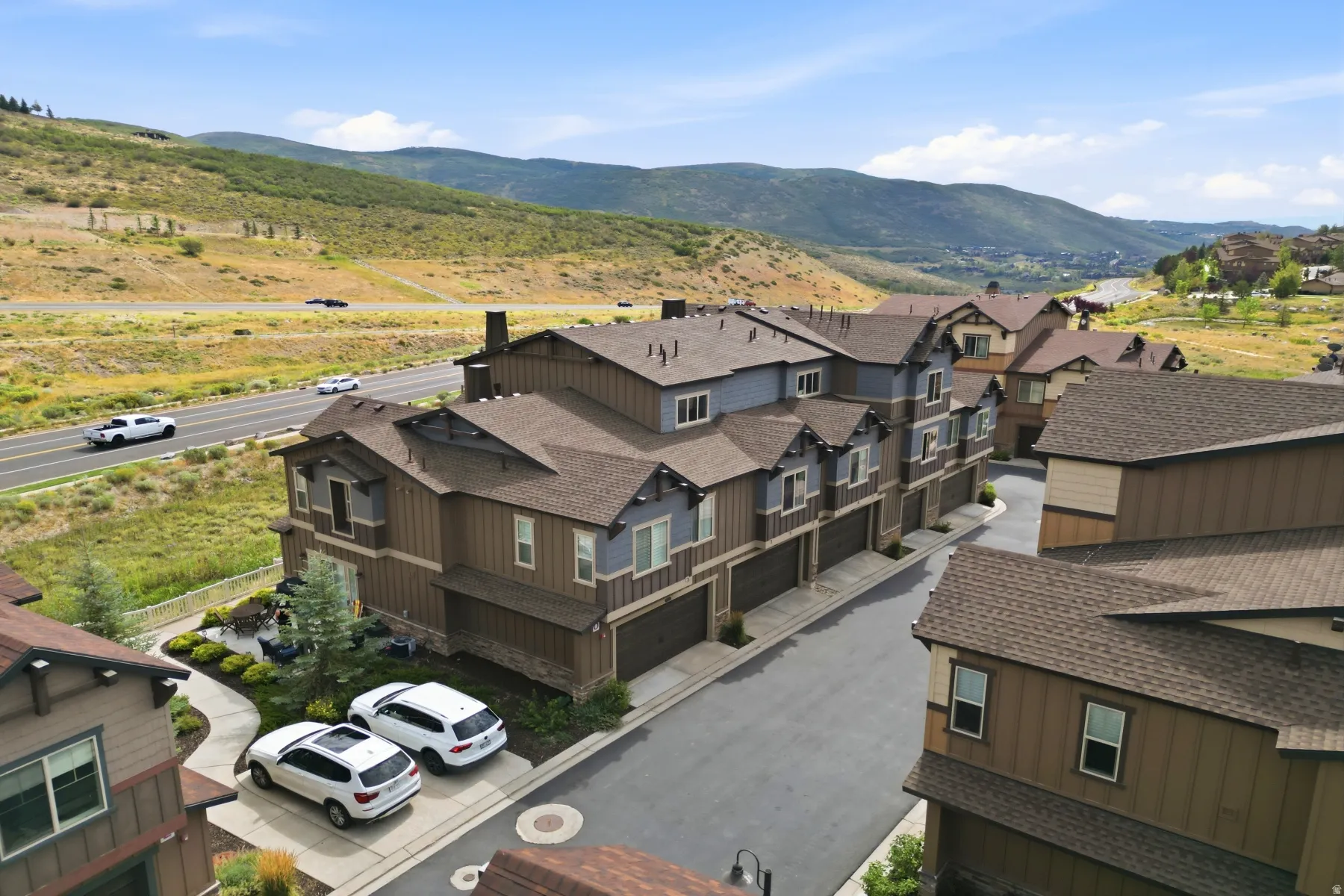 Townhome community featuring multi-level residences, attached garages, and a paved street
