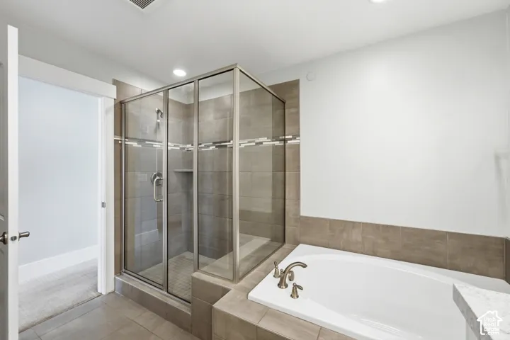 Walk-in shower with clear glass enclosure and tiled surround