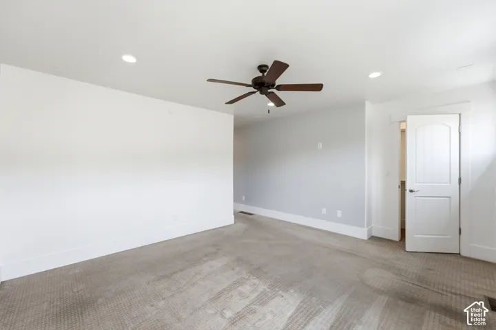 Recessed ceiling lighting, ceiling fan, carpeted flooring, and white interior door