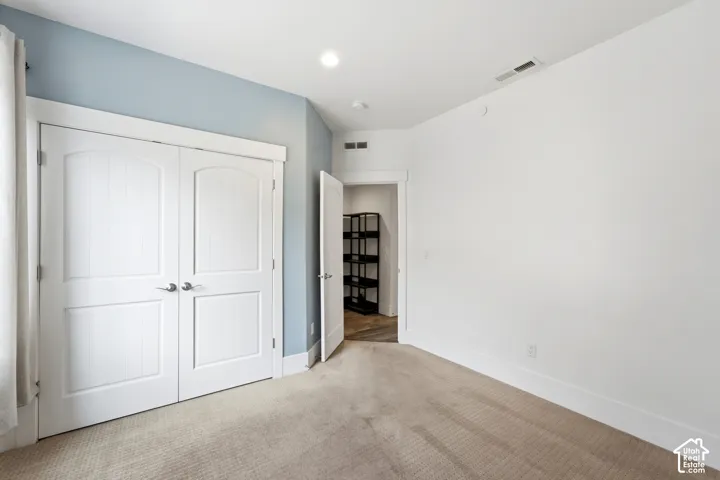 Carpeted flooring with white trim, double panel doors, and recessed lighting