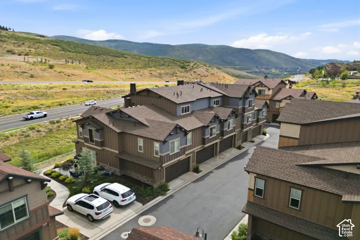 Townhome community featuring multi-level residences, attached garages, and a paved street