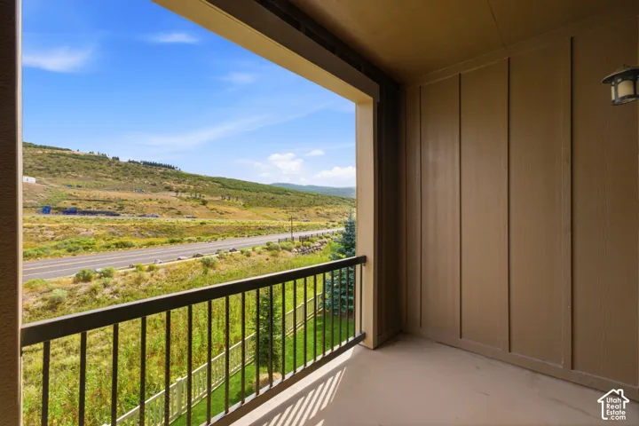 Private balcony featuring a metal railing and expansive mountain scenery